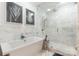 Bright white bathroom featuring a soaking tub and glass-enclosed shower with marbled tile and chrome fixtures at 222 S Caldwell St # 2203, Charlotte, NC 28202