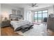 Bedroom featuring a large window with stunning city views, ceiling fan, hardwood floors, and neutral decor at 222 S Caldwell St # 2203, Charlotte, NC 28202
