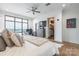 Bright bedroom featuring a large window with city views, a ceiling fan, and an en-suite bathroom at 222 S Caldwell St # 2203, Charlotte, NC 28202