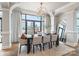 Sunlit dining room with a large table, modern chandelier, and stunning city views through expansive windows at 222 S Caldwell St # 2203, Charlotte, NC 28202