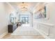 Elegant foyer with chandelier, decorative wall paneling, console table, and view of the city skyline beyond at 222 S Caldwell St # 2203, Charlotte, NC 28202