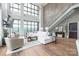 Elegant living room featuring high ceilings, a modern staircase, and panoramic city views at 222 S Caldwell St # 2203, Charlotte, NC 28202