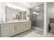 Spacious main bathroom features a double vanity, expansive mirror, and glass enclosed shower at 222 S Caldwell St # 2203, Charlotte, NC 28202