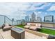 Inviting rooftop terrace with comfortable lounge furniture, a modern fire pit, and city skyline backdrop at 222 S Caldwell St # 2203, Charlotte, NC 28202