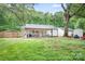 Large backyard featuring mature trees and a covered patio, great for outdoor activities at 2279 Cedar Oak Cir, Gastonia, NC 28052