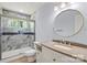 Bathroom featuring granite countertops, a round mirror, and a tile shower with a glass door at 2515 Danforth Ln, Charlotte, NC 28208