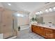 Bright bathroom featuring a garden tub, glass shower, double sinks, and a large mirror above the vanity at 2620 Yarrow Rd, Charlotte, NC 28213