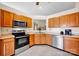 Functional kitchen featuring stainless steel appliances and warm oak cabinetry at 2620 Yarrow Rd, Charlotte, NC 28213