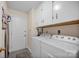 Functional laundry room equipped with a washer, dryer, and overhead cabinets for storing cleaning supplies at 2620 Yarrow Rd, Charlotte, NC 28213