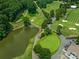 Picturesque aerial view of lush golf course and serene community lake at 3310 Windbluff Dr, Charlotte, NC 28277