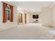 Finished basement featuring carpeted flooring, a TV setup, and a partial view of a hallway at 3310 Windbluff Dr, Charlotte, NC 28277