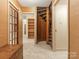 Hallway featuring unique spiral staircase and view of a room with bookshelves in the background at 3310 Windbluff Dr, Charlotte, NC 28277