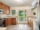 Bright kitchen featuring wood cabinets, granite countertops, and a door leading to the outdoors at 3310 Windbluff Dr, Charlotte, NC 28277