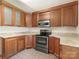Cozy kitchen featuring wood cabinets, stainless steel appliances, and tile flooring at 3310 Windbluff Dr, Charlotte, NC 28277