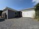A charming home exterior featuring gray siding, a gravel driveway, and a detached white garage for secure parking at 333 Mount View Ln # 266 B, New London, NC 28127