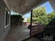 A beautiful outdoor porch with wooden floors, a ceiling fan, and lush greenery providing shade and privacy at 333 Mount View Ln # 266 B, New London, NC 28127
