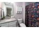 Bathroom featuring granite countertop, a vanity with a sink, toilet, cabinet, mirror, and a floral-patterned shower curtain at 360 Sexton St, Kannapolis, NC 28081
