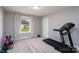 Bright bedroom with a treadmill, neutral carpet, a window with curtains, and ample space for workout equipment at 360 Sexton St, Kannapolis, NC 28081
