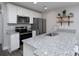 Well-lit kitchen with stainless steel appliances, white cabinets, granite countertops, and open shelving for decorative plants at 360 Sexton St, Kannapolis, NC 28081
