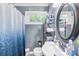 Bathroom featuring blue shower curtain, oval mirror, and shelf with toiletries at 411 Belvedere Cir, Kings Mountain, NC 28086