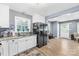 Well-lit kitchen showcasing white cabinetry, a stainless steel refrigerator and a view of the living room at 411 Belvedere Cir, Kings Mountain, NC 28086