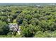 An aerial view of a home surrounded by a lush, green canopy of trees, showcasing its private setting at 4444 Steepleton Way, Charlotte, NC 28215
