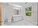 Well-lit bathroom with a vanity, mirror, and a window overlooking trees at 4444 Steepleton Way, Charlotte, NC 28215