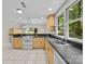 Bright kitchen with light wood cabinets, black countertops, stainless steel sink and views of the backyard at 4444 Steepleton Way, Charlotte, NC 28215