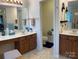 Bright bathroom featuring double sinks with wood cabinets and separate toilet area at 5009 Brook Valley Run, Monroe, NC 28110