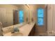 Bathroom with dual sinks, a large mirror, and ample natural light from two windows at 5009 Brook Valley Run, Monroe, NC 28110
