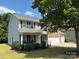 Well-manicured front yard with lush green grass and mature trees surrounding this two-story, brick and vinyl home at 5009 Brook Valley Run, Monroe, NC 28110