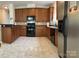 Functional kitchen features wooden cabinetry, black appliances, and ample counter space for meal preparation and dining at 5009 Brook Valley Run, Monroe, NC 28110
