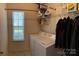 Convenient laundry room featuring a washer, dryer, shelving, and a window for natural light at 5009 Brook Valley Run, Monroe, NC 28110