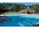 Community pool and clubhouse with clear blue water surrounded by lounge chairs at 5009 Brook Valley Run, Monroe, NC 28110