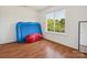 Bright bedroom with wood floors, large window offering natural light, with a blue air mattress at 5701 Silver Eagle Dr, Charlotte, NC 28214