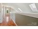 Upstairs hallway featuring hardwood floors, skylights, a dormer window, and neutral paint at 5701 Silver Eagle Dr, Charlotte, NC 28214