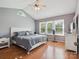 Sunlit bedroom with vaulted ceiling, hardwood flooring, ceiling fan, and large windows at 5701 Silver Eagle Dr, Charlotte, NC 28214