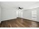 Open living room with hardwood floors, a ceiling fan, and ample natural light from large windows at 5717 Fairchase Ave, Charlotte, NC 28269
