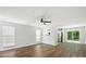 Bright and airy living room featuring hardwood floors, a ceiling fan, and sliding doors to the backyard at 5717 Fairchase Ave, Charlotte, NC 28269