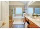 This bathroom offers a soaking tub with a glass block window and a dual sink vanity at 7521 Plumcrest Ln, Harrisburg, NC 28075