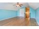 Bright bedroom with hardwood floors, blue walls, and a ceiling fan at 7521 Plumcrest Ln, Harrisburg, NC 28075