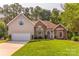 Charming two-story home featuring a well-manicured lawn and attached two-car garage at 7521 Plumcrest Ln, Harrisburg, NC 28075
