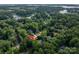 Aerial view shows the home nestled among lush greenery near a lake, highlighting a serene and desirable location at 7988 Golf Course N Dr, Denver, NC 28037