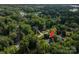 Aerial view showcases the property nestled among mature trees, highlighting its prime location near the lake at 7988 Golf Course N Dr, Denver, NC 28037