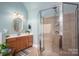 A clean, bright bathroom featuring a tiled shower with glass door and single sink vanity at 7988 Golf Course N Dr, Denver, NC 28037