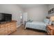 A comfortable bedroom featuring a queen bed, a wooden dresser, and soft natural light at 7988 Golf Course N Dr, Denver, NC 28037