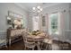 Dining room featuring a round table, neutral color palette, elegant sideboard, and decorative mirror at 7988 Golf Course N Dr, Denver, NC 28037