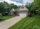 Beautiful brick home featuring a long driveway and a well-manicured lawn at 7988 Golf Course N Dr, Denver, NC 28037