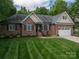 Attractive brick home featuring a well-manicured lawn and a two-car garage at 7988 Golf Course N Dr, Denver, NC 28037