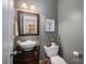 Stylish half bath with vessel sink, dark vanity, and botanical decor at 7988 Golf Course N Dr, Denver, NC 28037